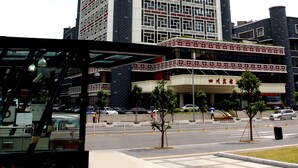 A tall, modern building with a grid-like facade and a cylindrical section near the top. - Shenzhen Sichuan Hotel (Shenzhen)