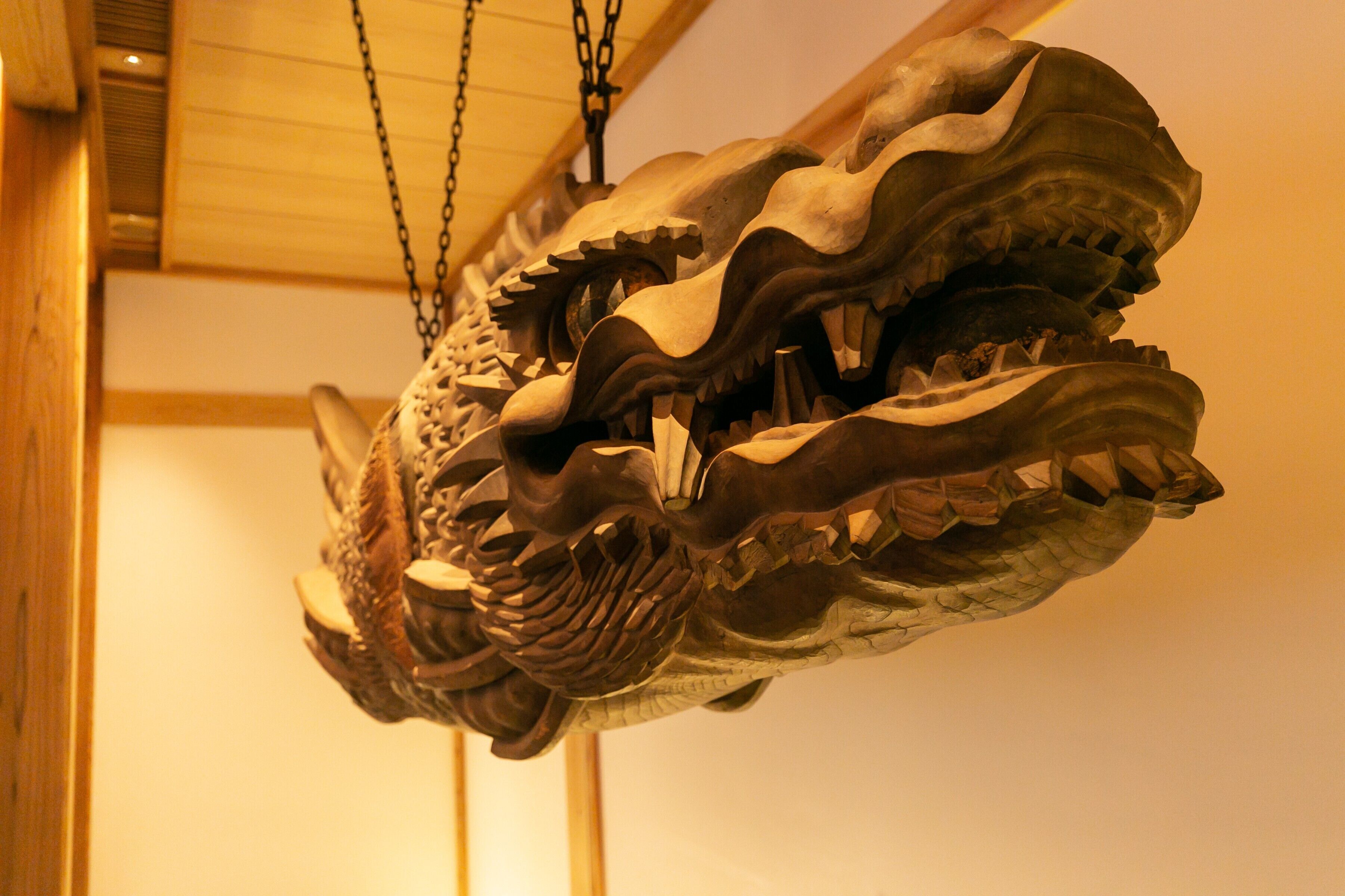 A large, intricately carved wooden dragon sculpture suspended from the ceiling.