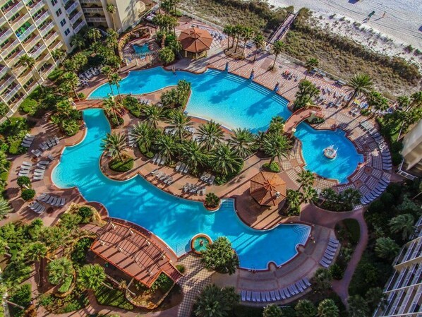 Relax by the multi-tiered pool surrounded by lush greenery and palm trees.