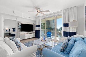 Relax in a spacious room with a large TV, comfortable seating area, and balcony.
