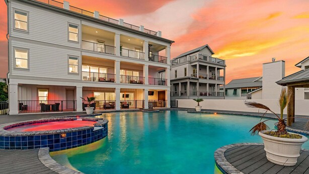Un immeuble à plusieurs étages doté de balcons, d’une piscine avec un jacuzzi et d’une terrasse en bois.