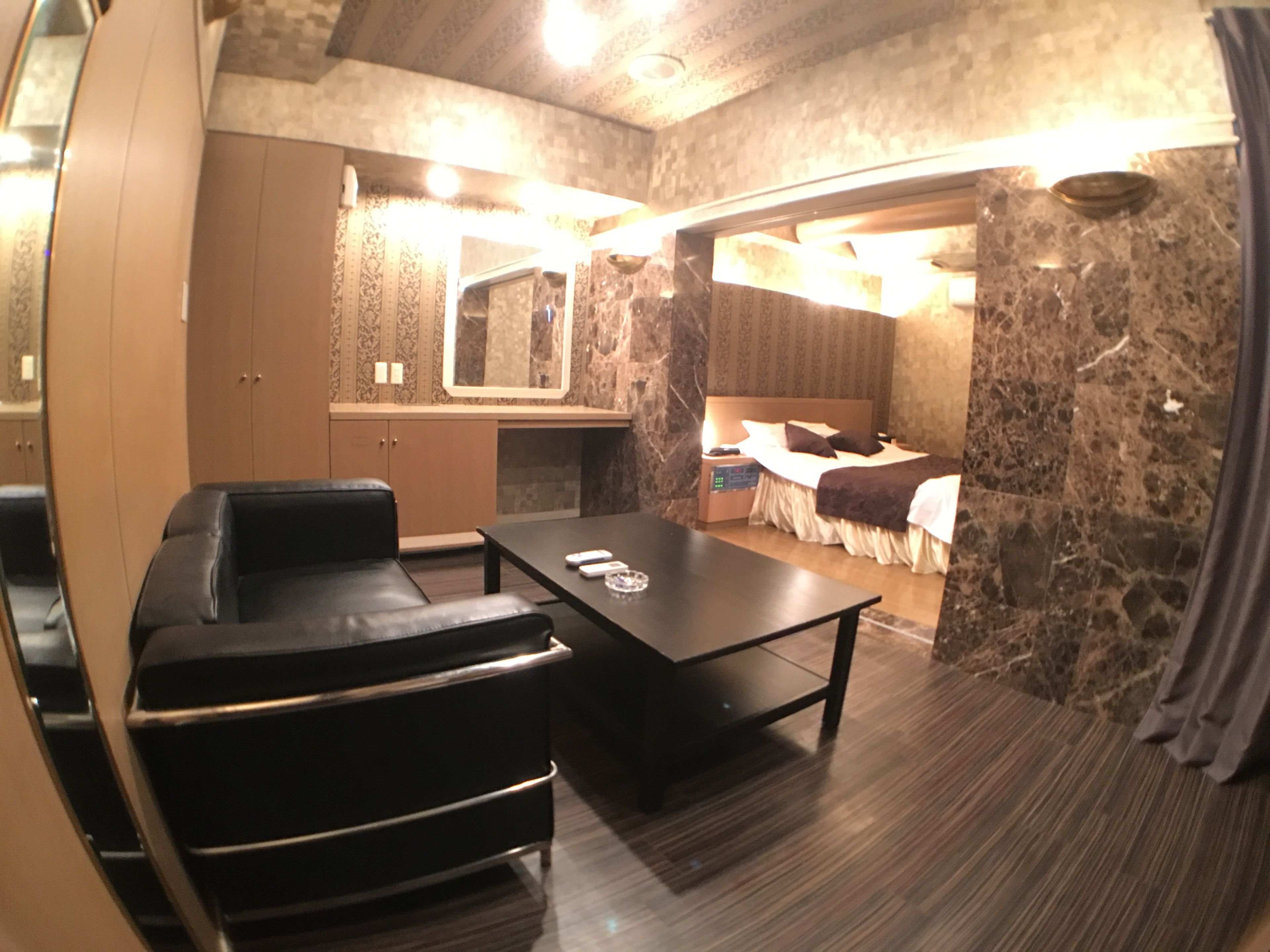 Une chambre d’hôtel comprenant un lit, un bureau, une chaise, un miroir et une armoire.