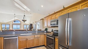 Una cocina amplia con armarios de madera, un refrigerador de acero inoxidable y un microondas.