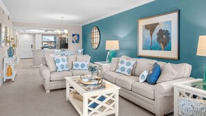 A living room with two sofas, a coffee table, and a dining area in the background. - Gulf-View & Fully Renovated Condo E31— Steps to the Beach at Pointe Santo (Sanibel)