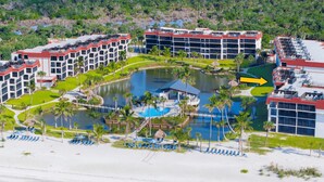 A resort with multiple buildings, a central pool, and a beach area. - Gulf-View & Fully Renovated Condo E31— Steps to the Beach at Pointe Santo (Sanibel)