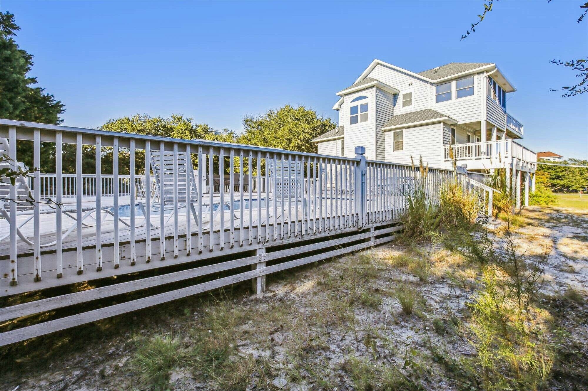 A two-story house with a balcony, a covered patio, and a fenced deck.