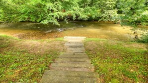 A wooden staircase leading to a river surrounded by dense green foliage. - Dog Friendly 10 Acre Retreat Fly Fishing and Pond (Mineral Bluff)