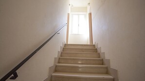 Eine Treppe führt zu einer Tür mit einem Fenster darüber.
