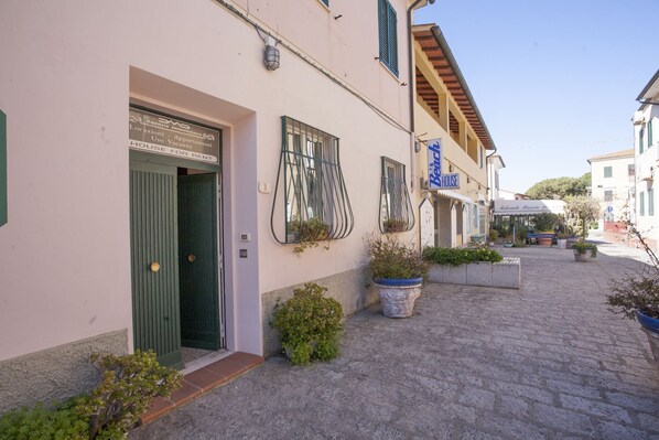 Un edificio con una puerta verde que indica "Use for Rent" y un cartel para el restaurante "Back House".