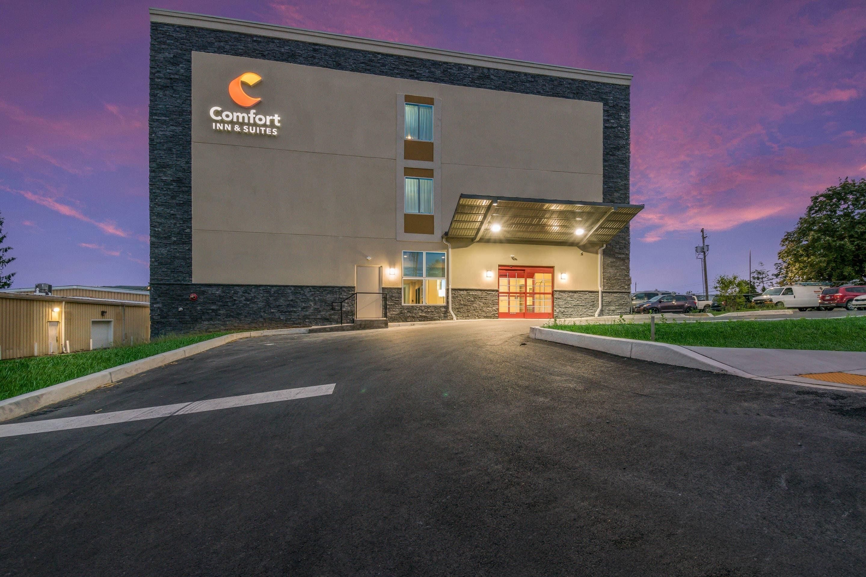 A Comfort Inn & Suites building with a stone facade, a central entrance, and a parking lot.