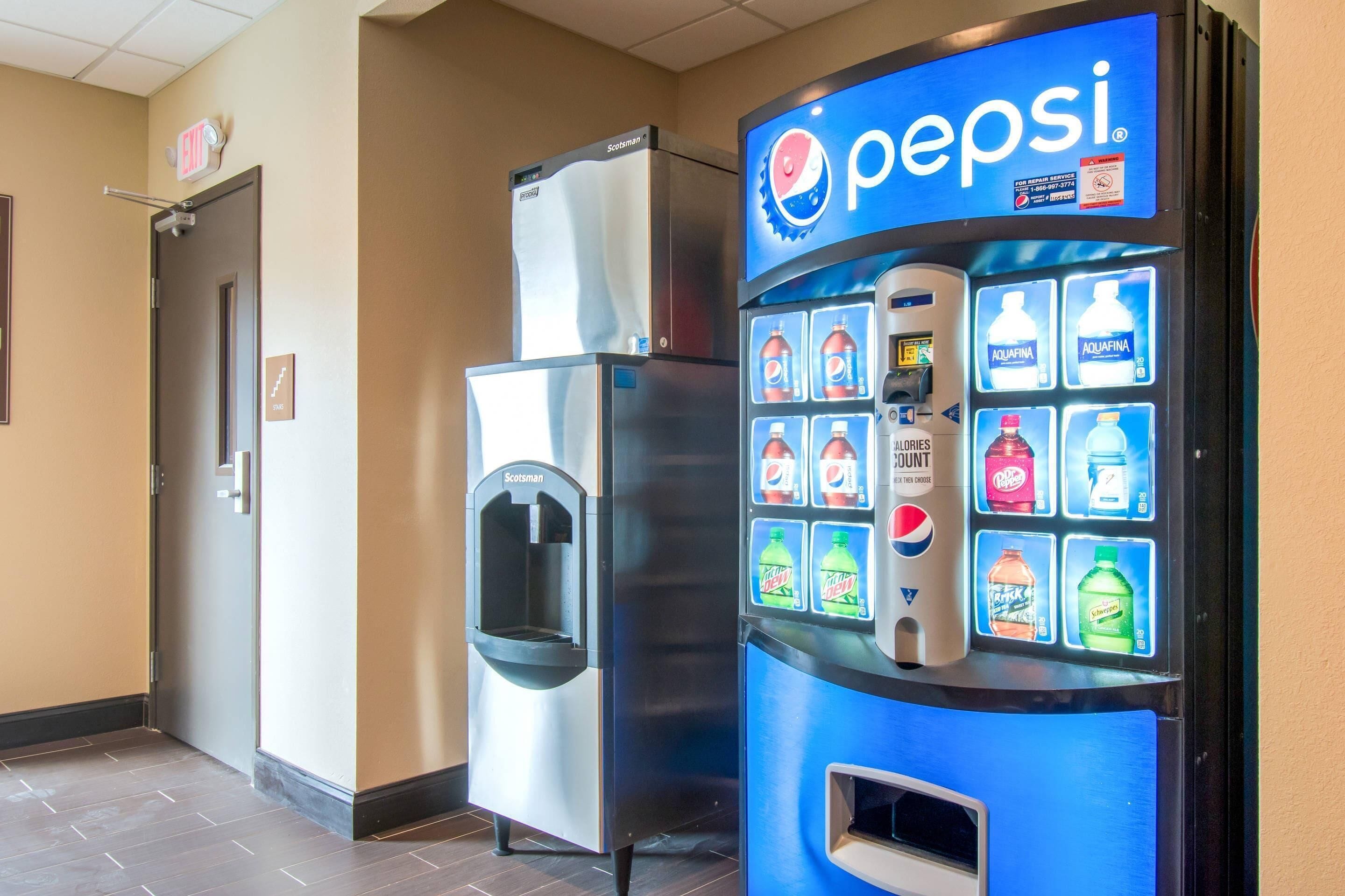 A vending machine with a Pepsi logo, a water dispenser, and a refrigerator.