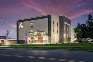 A hotel with a modern design, featuring a prominent 'Comfort Inn & Suites' sign, a covered entrance, and a parking area with several vehicles. - Comfort Inn & Suites Harrisburg - Hershey West (Harrisburg)