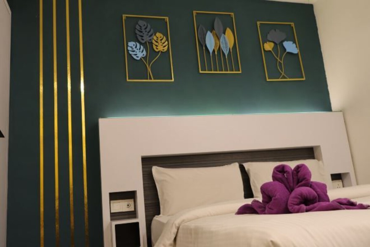 Una habitación de hotel con cama, mesita de noche y decoración en la pared.