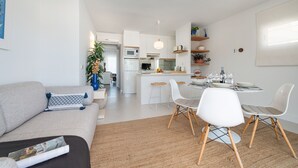 A modern apartment with a living room, dining area, and kitchen. - Charming apartment on the beach with fantastic views in Puerto de Alcudia (Port d´Alcudia)