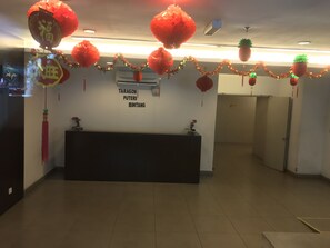 A reception area with a dark reception desk, red lanterns, and a sign reading "TARAGON PUTERI BINTANG". - KL Taragon Apartment (Kuala Lumpur)