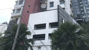 Un grand immeuble résidentiel doté de nombreux balcons et d’une section centrale de couleur rouge.