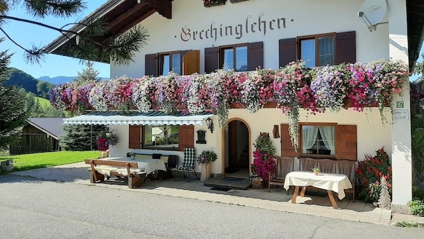 Un edificio tradicional de Brechlingchen con una entrada acogedora, mesas al aire libre y vistas del paisaje circundante.