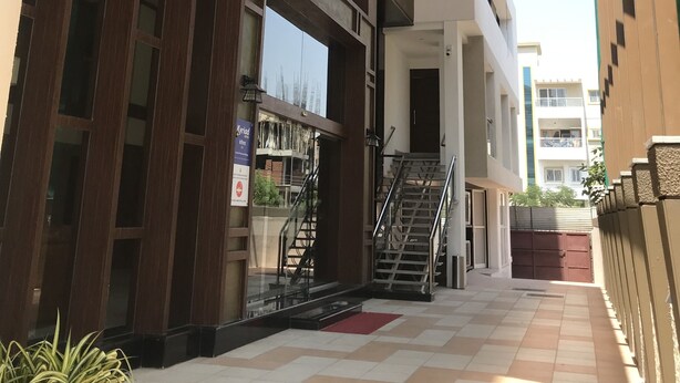 A modern building with a glass facade, a staircase, and a tiled walkway.