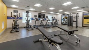 A gym with treadmills, elliptical machines, and weight benches. - Hampton Inn Camden (Camden)