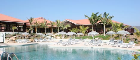 Una piscina al aire libre, camas de piscina gratis, sombrillas