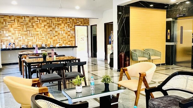 A modern lobby with a dining area, seating arrangements, and a reception desk. - Namaha Stays (Hyderabad)