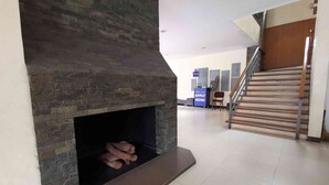 Un intérieur moderne agrémenté d’une cheminée en pierre, d’un escalier et d’un comptoir d’accueil.