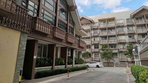 Un hôtel à plusieurs étages doté de balcons, d’un parking et offrant une vue sur un ciel dégagé.