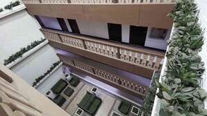 Un atrium à plusieurs niveaux, doté de balcons, de plantes vertes et d’espaces aménagés pour s’asseoir.