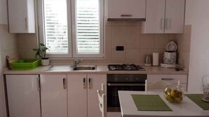 A modern kitchen with a sink, stove, and cabinets. - Villa with air conditioning, terrace and outdoor pool (Rogoznica)