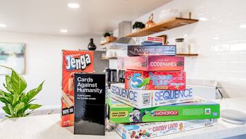A stack of board games on a kitchen counter.