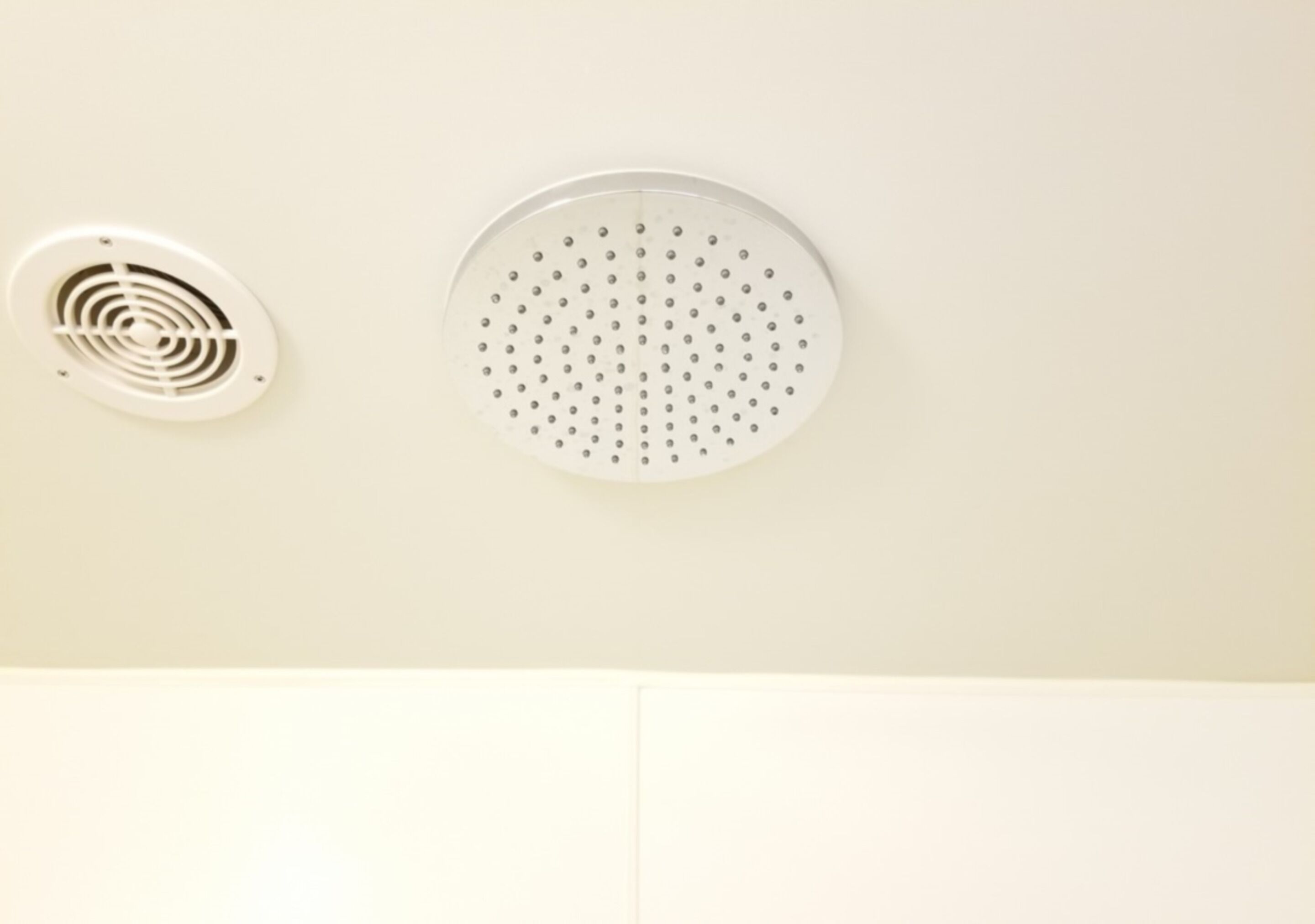 A ceiling with two ventilation units, one circular and one with a spiral design.