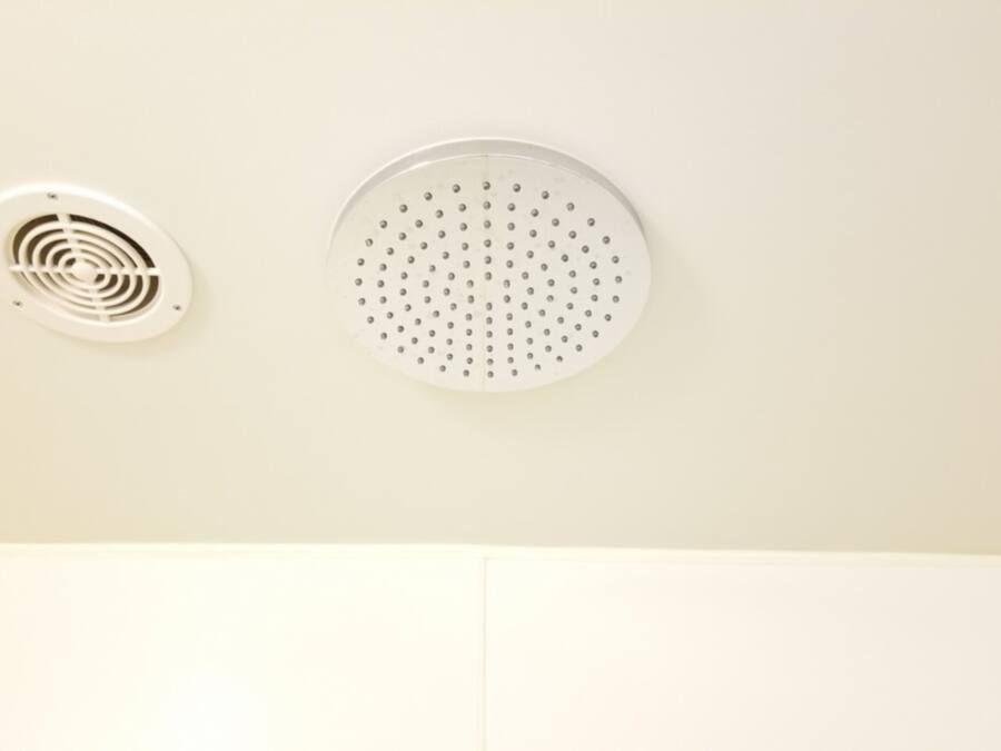 A ceiling with two ventilation units, one circular and one with a spiral design.