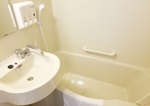 A bathroom with a white sink, a mirror, a handheld showerhead, and a bathtub with a grab bar. - Toyoko Inn Ebina Station Higashi (Ebina)