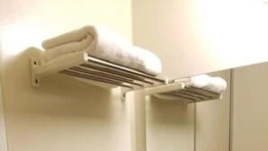 A bathroom with a towel rack holding two folded towels.