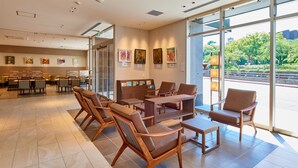 A spacious lobby with modern furniture, large windows, and artwork on the walls. - &and COMFY HOTEL Kumamotojo View (Kumamoto)