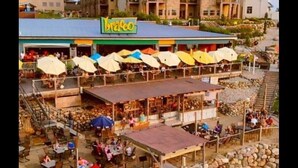A beachfront restaurant with outdoor seating and a covered area.