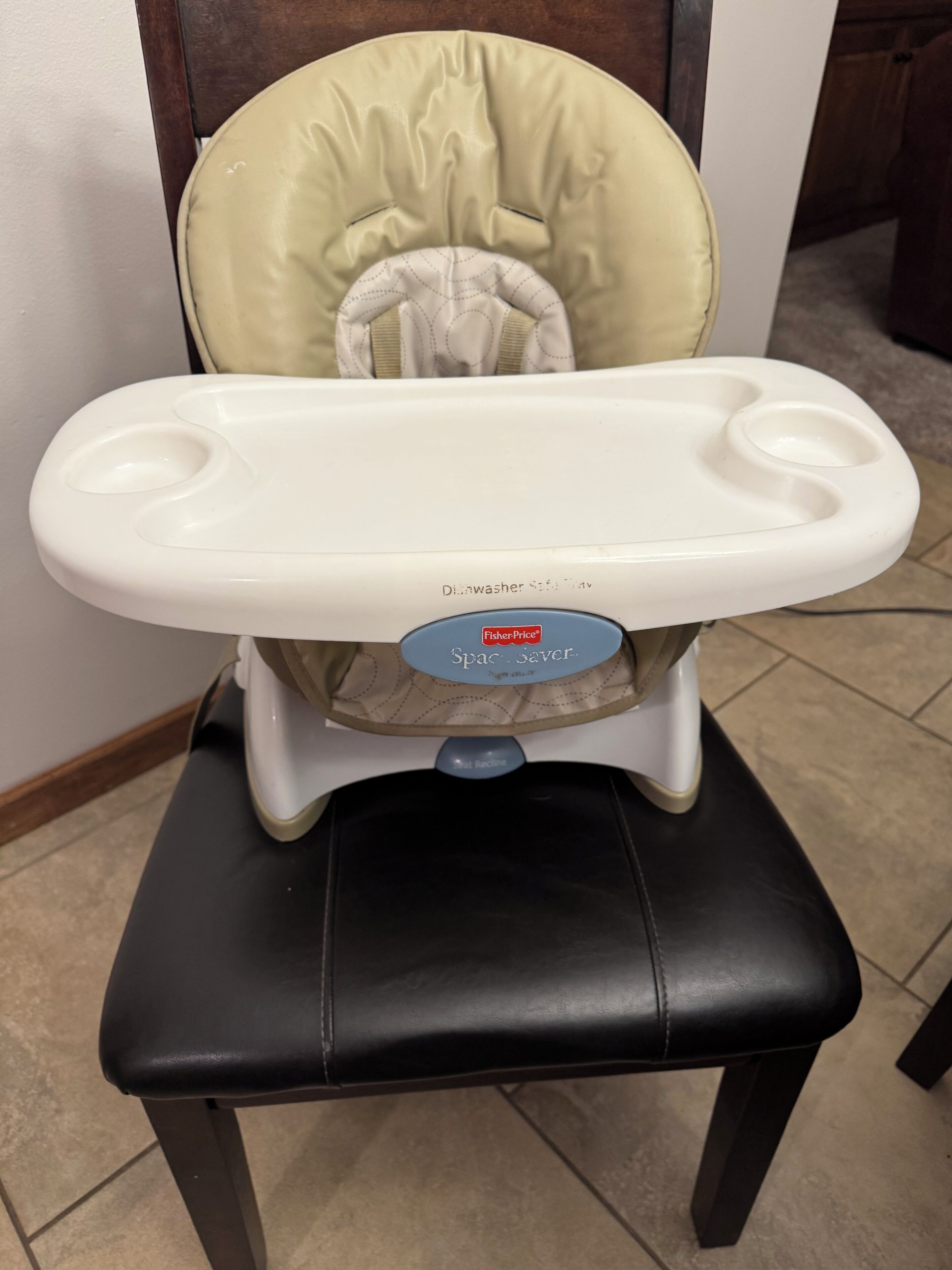 A high chair with a padded seat and a tray table.