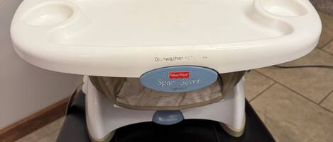 A high chair with a padded seat and a tray table.