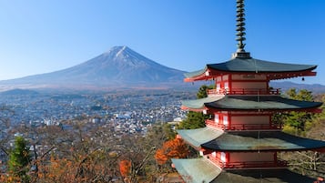 A pagoda with multiple tiers, a mountain in the background, and a cityscape below.