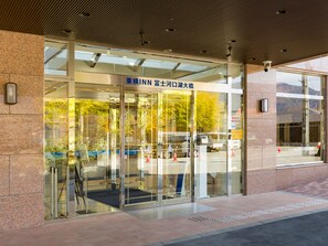 A hotel entrance with a glass facade, a sign in a foreign language, and a view of the surrounding area. - Toyoko Inn Fuji Kawaguchiko Ohashi (Fujikawaguchiko)