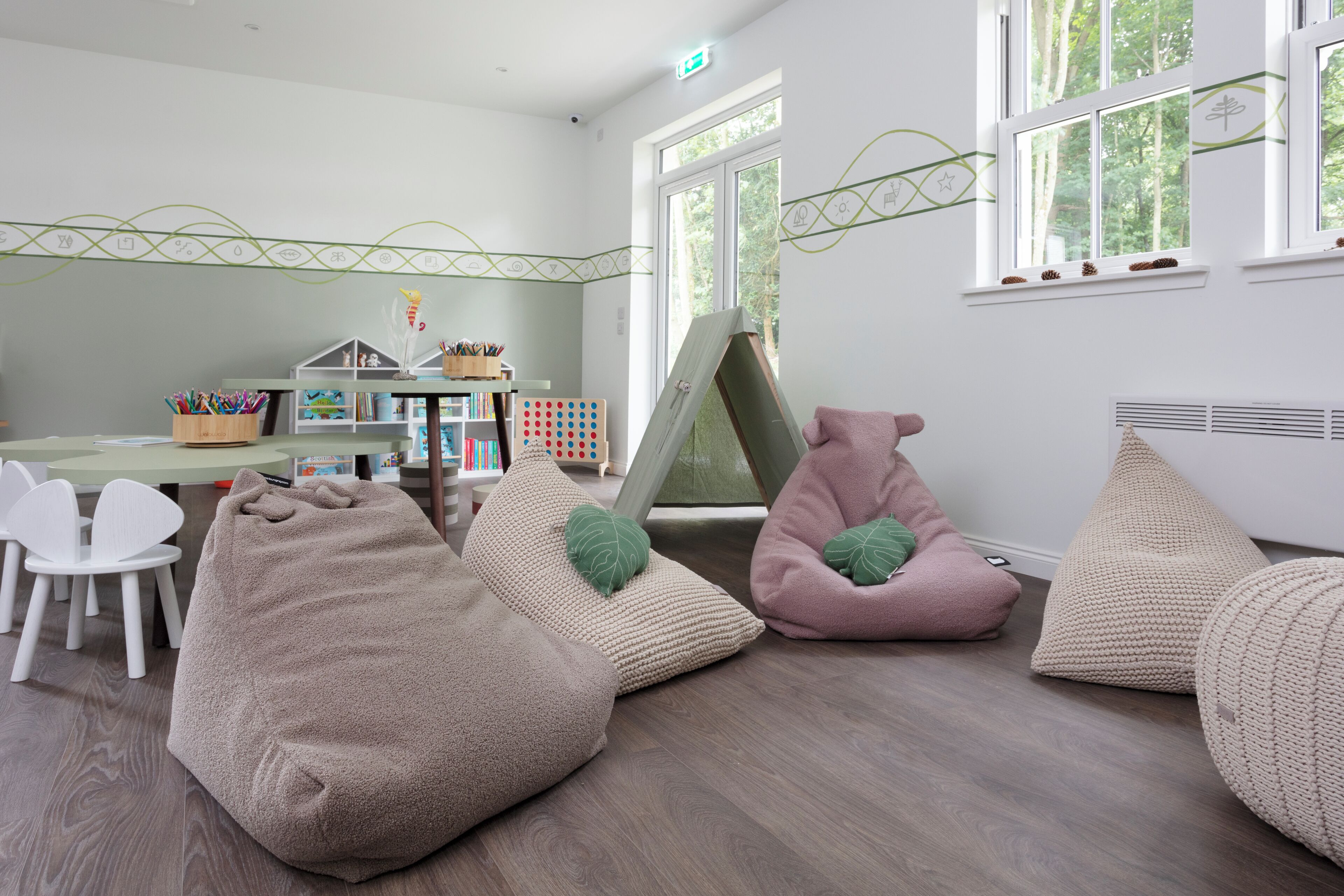 A cozy room with bean bags, a table with chairs, and a bookshelf.