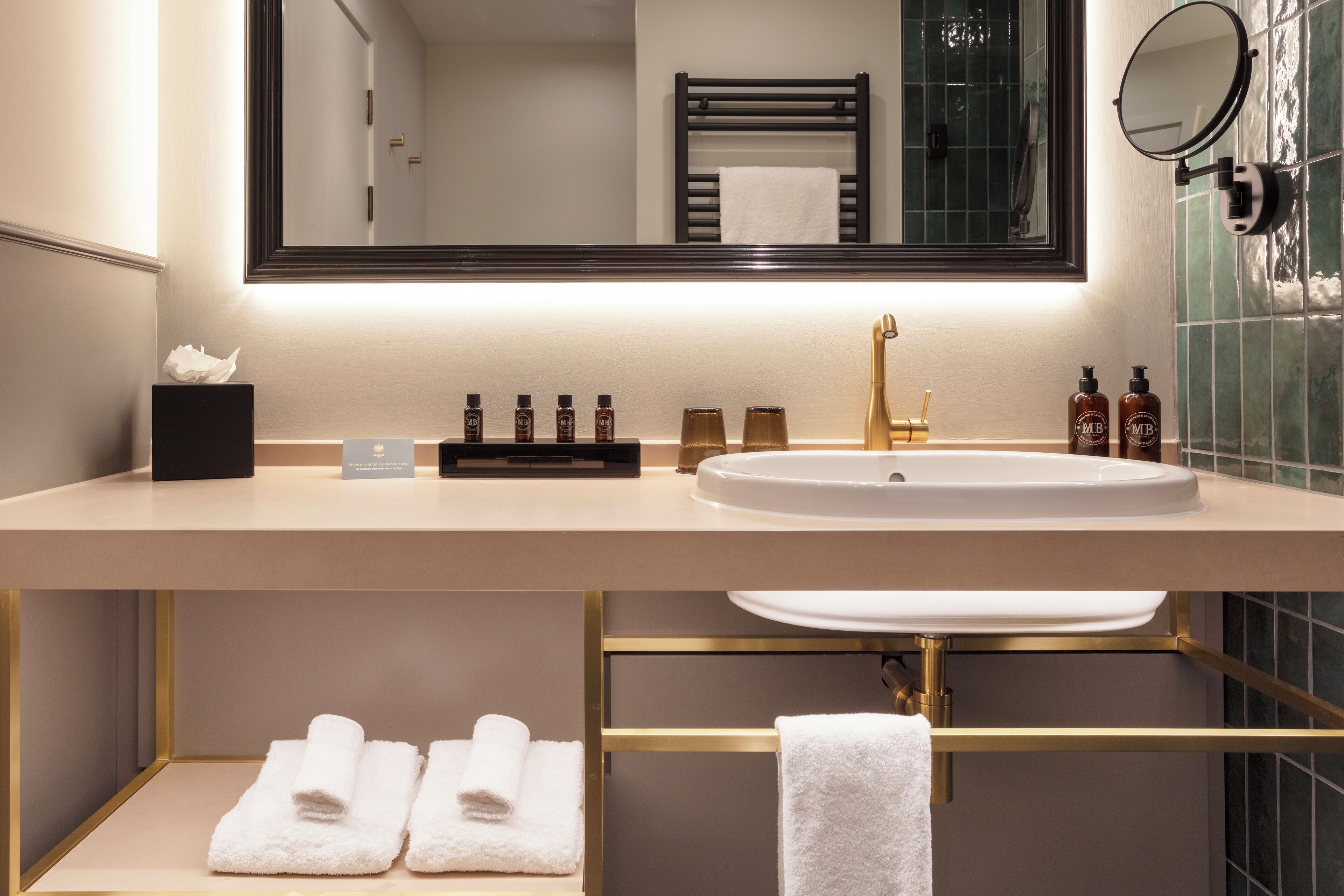 A modern bathroom with a large mirror, a sink, and a towel rack.