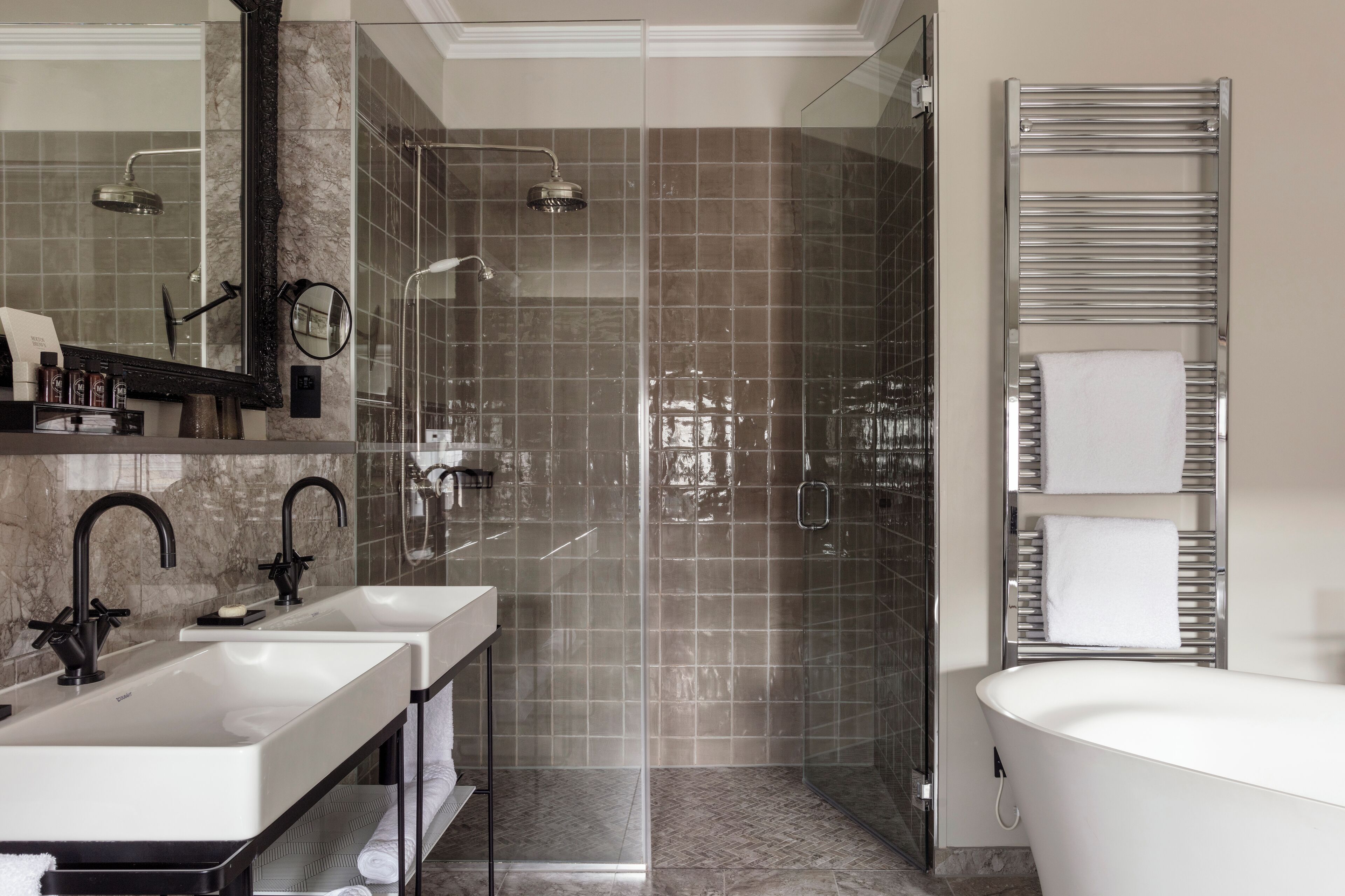 Un baño moderno con dos lavamanos, un espejo grande, cabina de ducha y bañera.