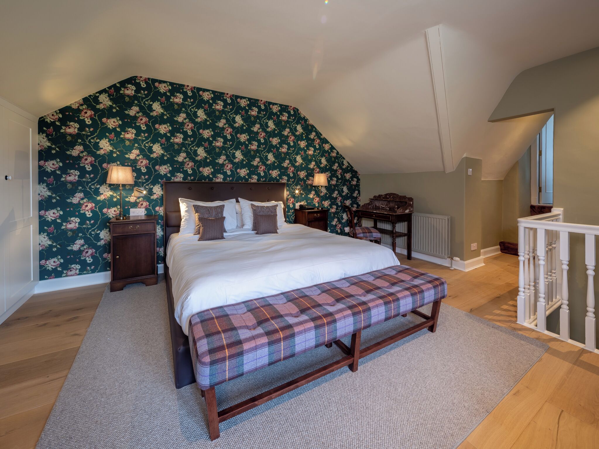 Ein Schlafzimmer mit einem großen Bett, einer Bank, einem Schreibtisch und einem Klavier.