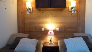 A cozy room with two beds, wooden walls, and wall-mounted lamps. - BELLE PLAGNE, cosy 2 rooms, skis on / cleaning and covered parking included !!! (La Plagne Tarentaise)