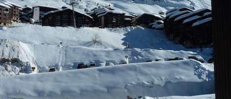 A snow-covered ski resort with buildings and a mountain in the background.