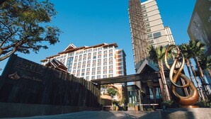 L’entrée d’un hôtel au design moderne, avec une grande sculpture et une enseigne indiquant « Astra Suites ».