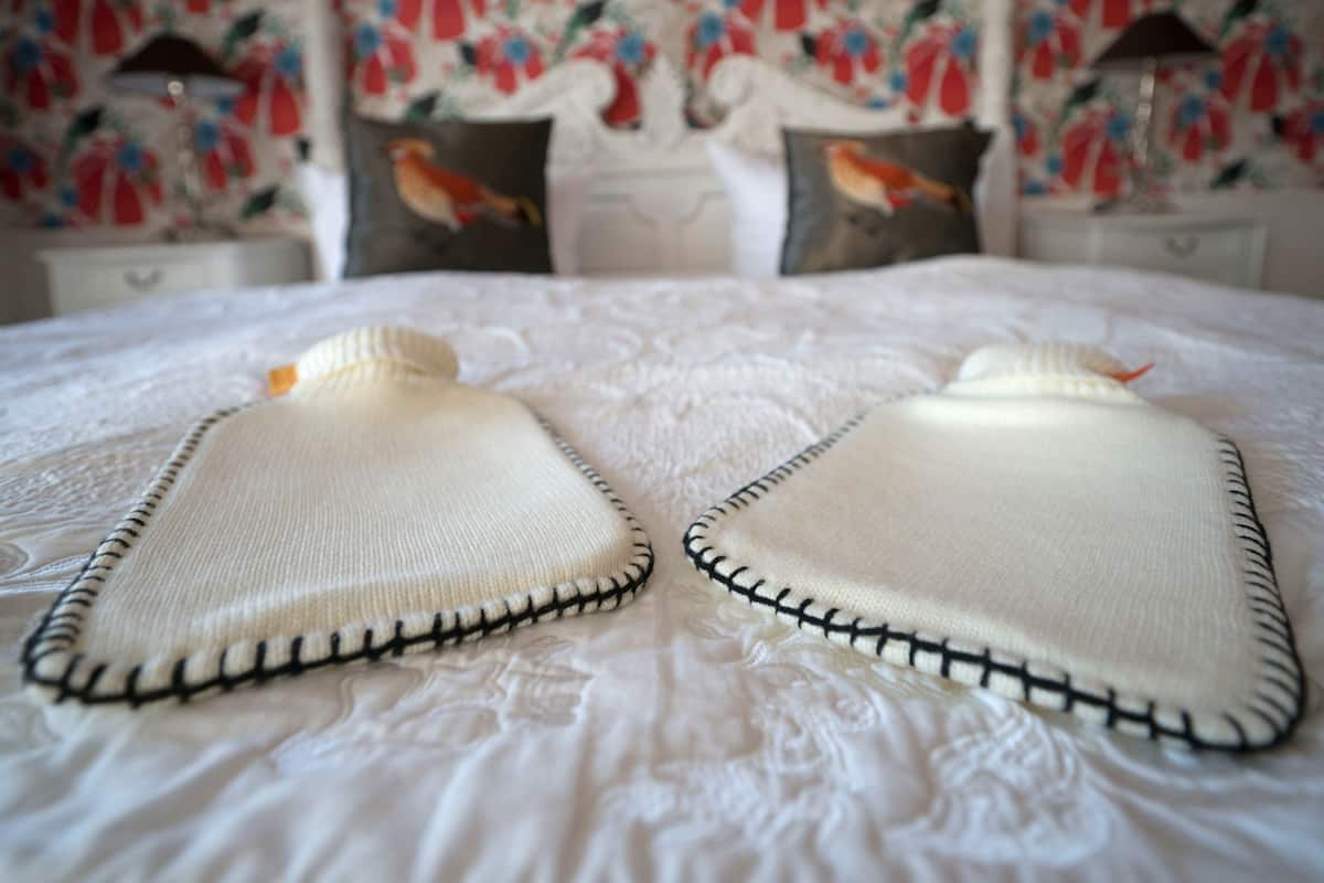 Ein Bett mit weißer Bettdecke und Kissen mit Blumenmuster.