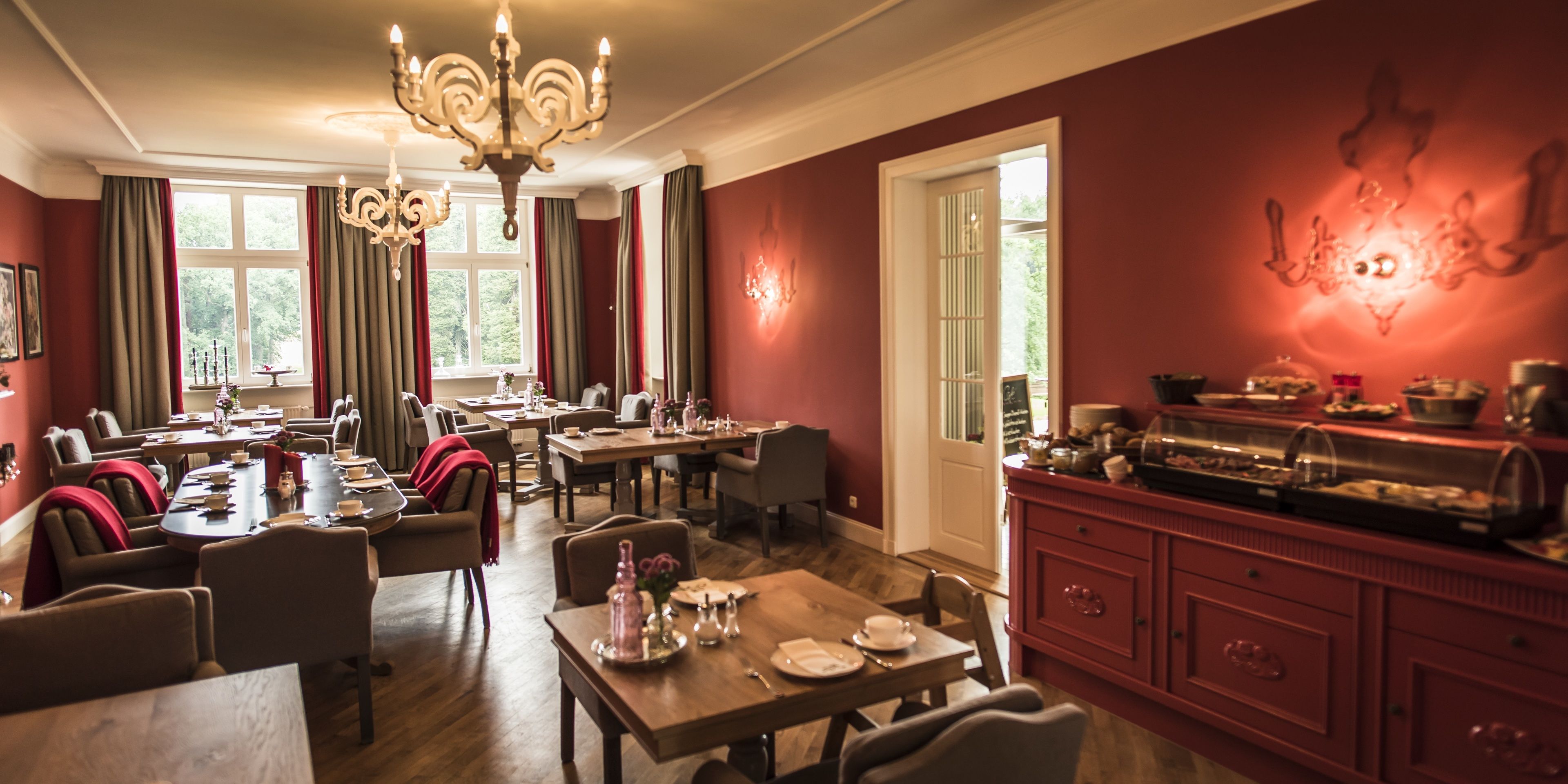 Een eetruimte met meerdere tafels, stoelen en een buffet.
