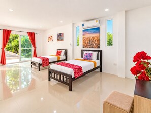 A hotel room with two beds, a large window with red curtains, a painting on the wall, and a potted plant.